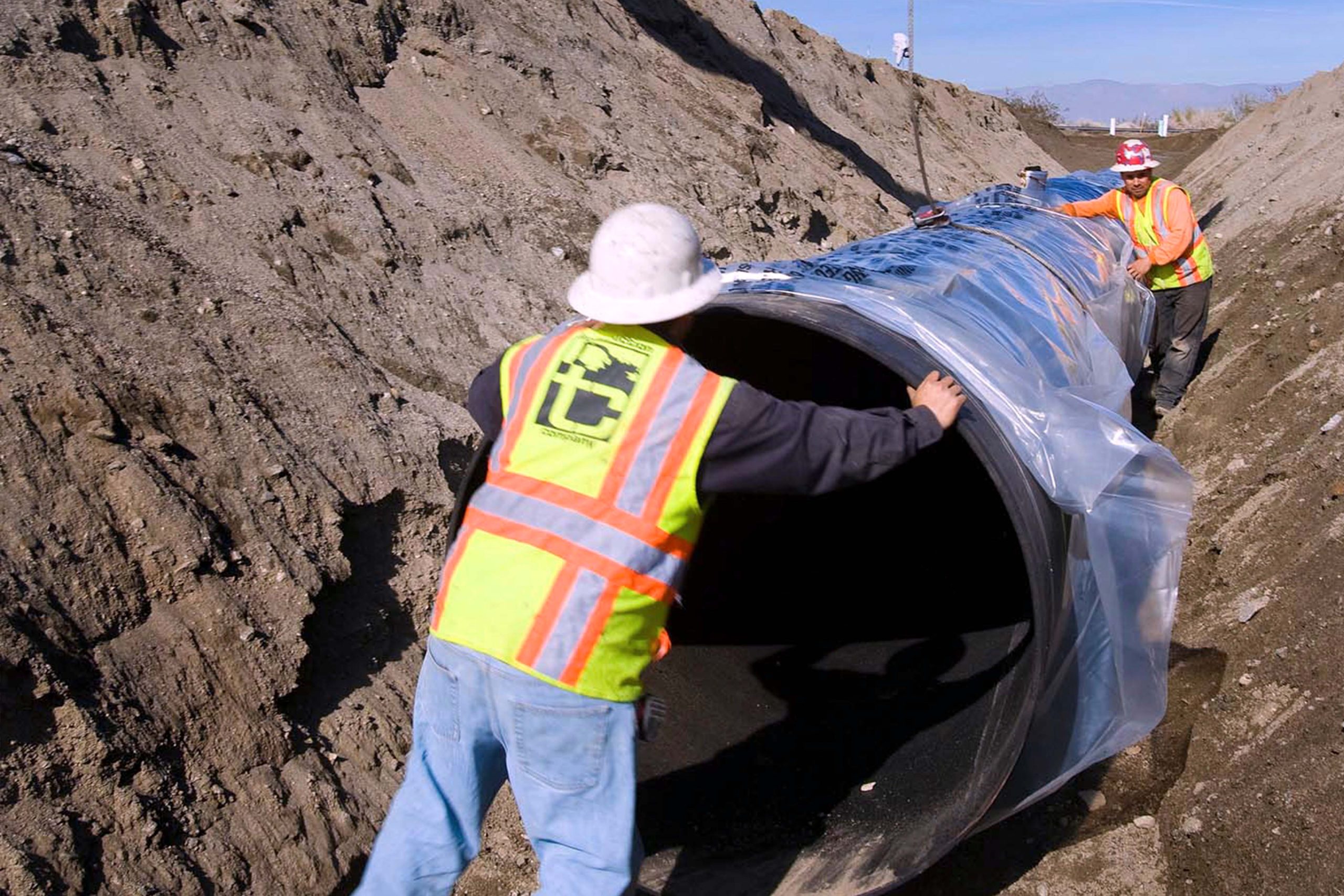 Dike 4 Pump Station & Recharge Basins - workers with larch pipe in trench