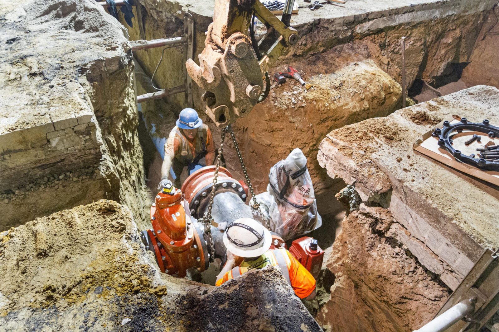 13-027 Sewer and Water Group 957, workers are installing a large underground pipe connection