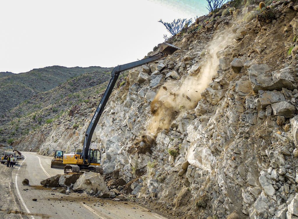 13-029 Montezuma Valley Road S22 Emergency Slope Repair, excavator knocking large loose rocks off slope