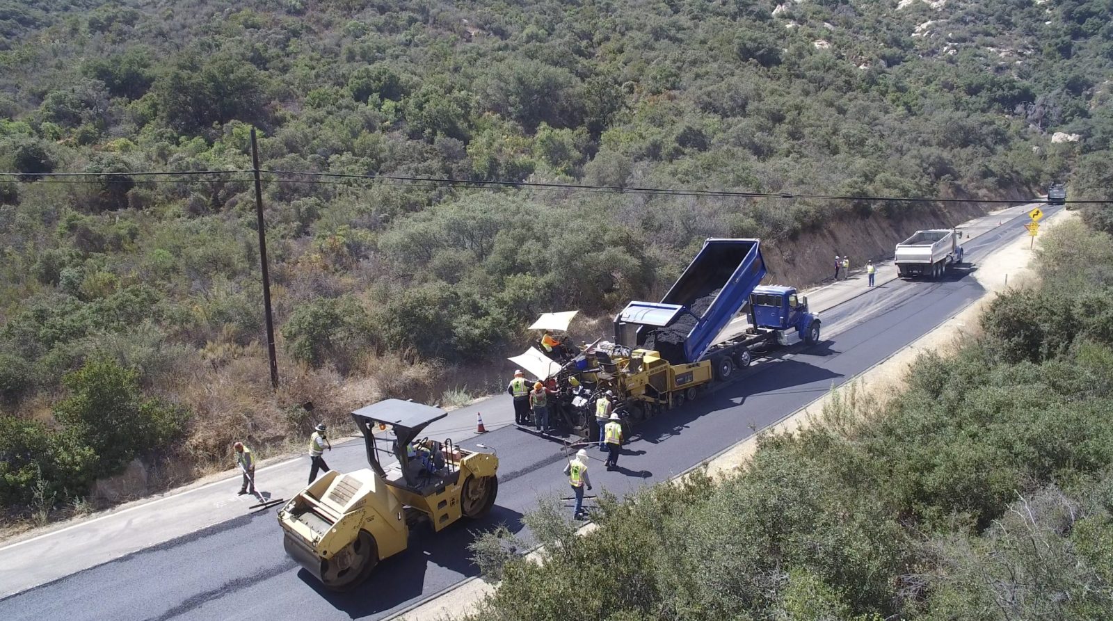 18604 County Overlay Road Maintenance, view of paving crew laying asphalt on winding mountain road