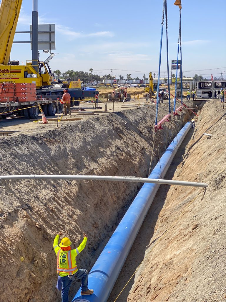 22013 La Media Road Improvements workers installing steel water pipe with crane