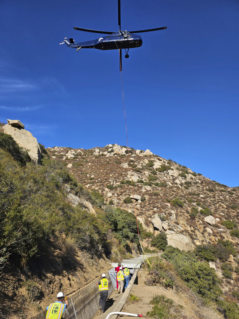 Helicopter lifting metal section into place on Dulzura flume